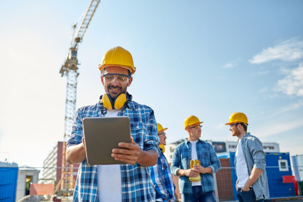builder in hardhat with tablet pc at construction